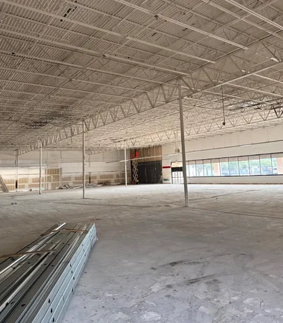 Bare concrete slab swept clean after strip out, with steel stud track stacked ready