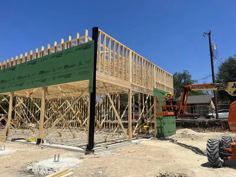 Steel columns and wood framing being set with a lift on a commercial site