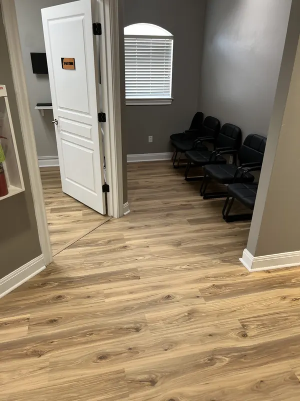 Plank flooring installed in an office with fresh white baseboards