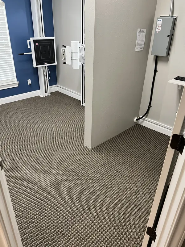 Grey loop carpet installed in a bedroom with navy accent wall
