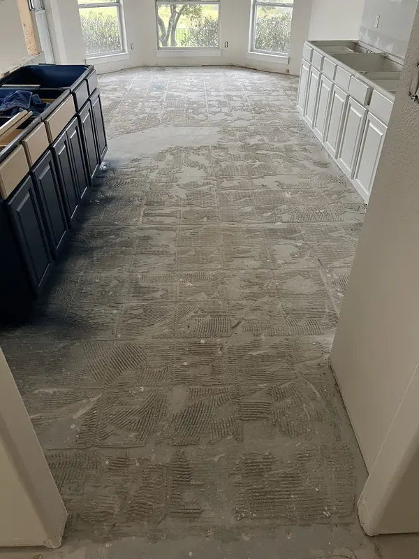 New flooring being installed around a navy kitchen island