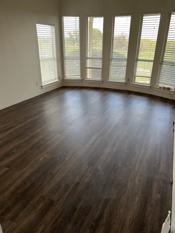 Dark plank flooring installed in a bay window sitting room