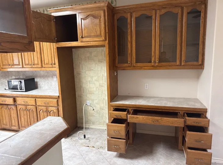 Kitchen before the remodel, oak cabinets with glass fronted uppers and a tiled built in desk