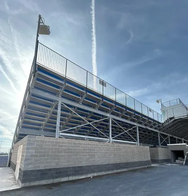 Finished grandstand with steel framing, blue seating and a black perimeter railing